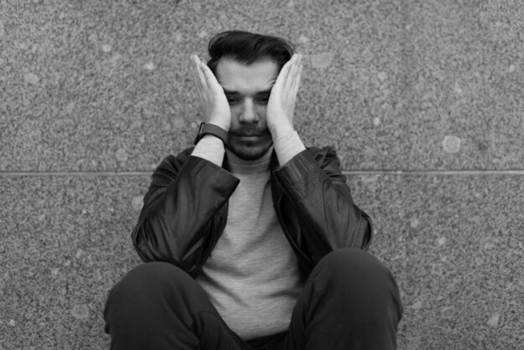 Man with hands on face.