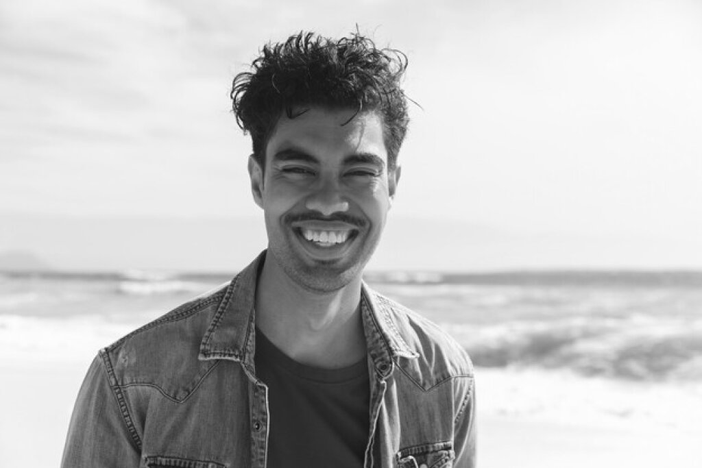 Man smiling by ocean.